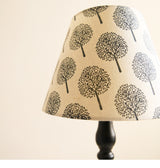 Close view of a shade printed with black tree silhouettes on cream