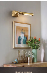 Brass tube lit over a framed print above a console with stacked books