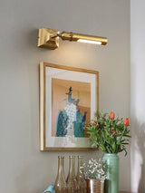 Brass tube lit over a framed print in a corner with tall glass vases