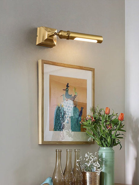 Brass tube lit over a framed print in a corner with tall glass vases