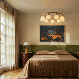 The ring lit above a bed with a framed painting on the wall behind it