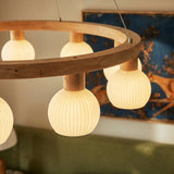Three lit ribbed globes seen close with a blue framed artwork behind them