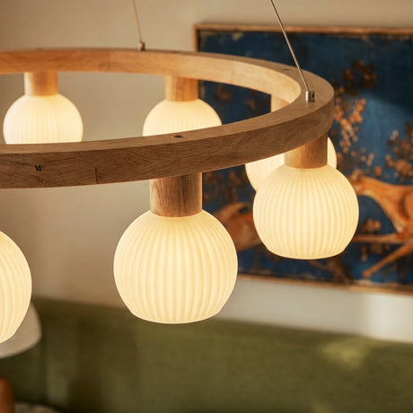 Three lit ribbed globes seen close with a blue framed artwork behind them