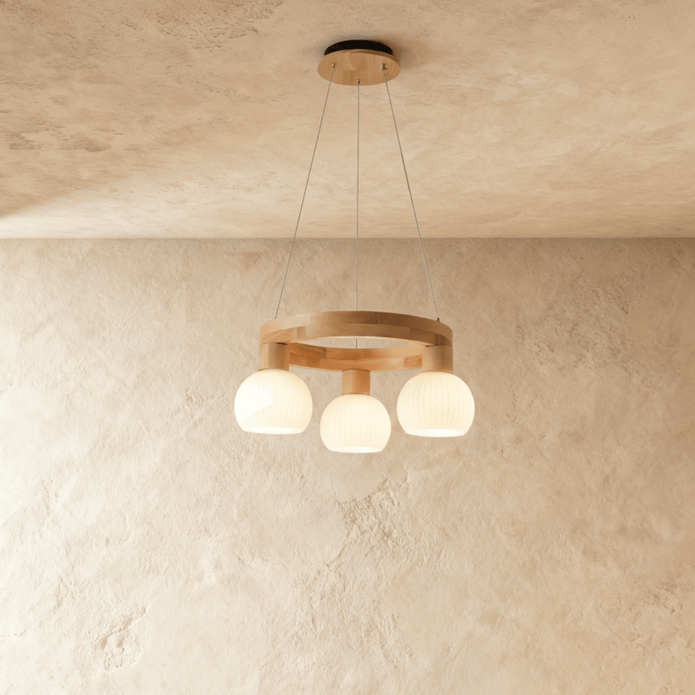 A pale wood ring carrying three ribbed glass globes on short drops