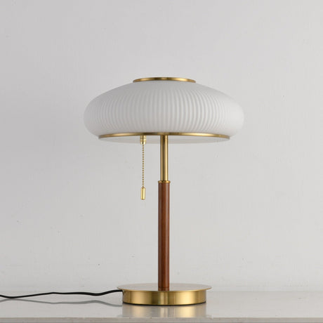 Ribbed glass table lamp unlit seen from the front on a pale ground