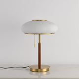Full view of the ribbed glass table lamp against a pale ground