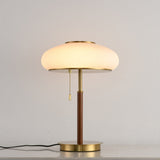 Ribbed glass table lamp lit against a plain pale ground