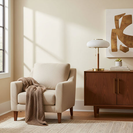 Ribbed glass table lamp on a wood sideboard in a pale room
