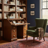 Ribbed glass table lamp on a writing desk against a blue wall
