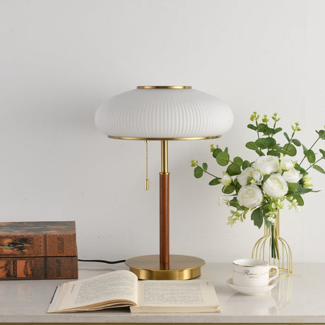Ribbed glass table lamp unlit beside white roses, the ribs visible