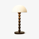 Rice paper table lamp with a dome shade on a stacked wood base, plain background