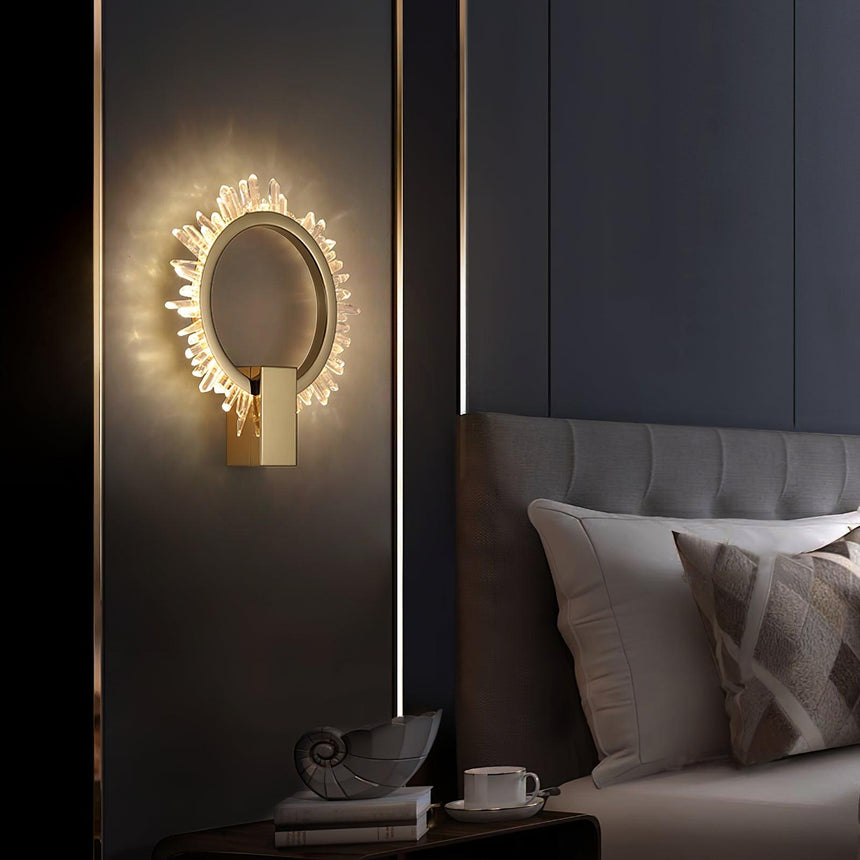 The ring glowing on a dark wall beside a bed with gray pillows