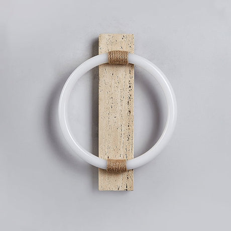 The white ring and the travertine slab with the light off, the rope wraps at top and bottom