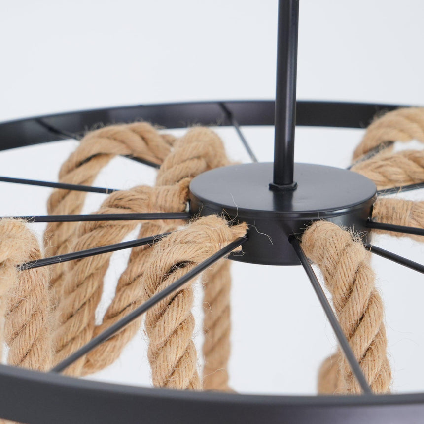 The spoked black iron ring seen from below with rope threaded over it