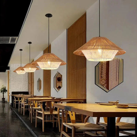Hemp rope shade lit above a dining table in a dark paneled room