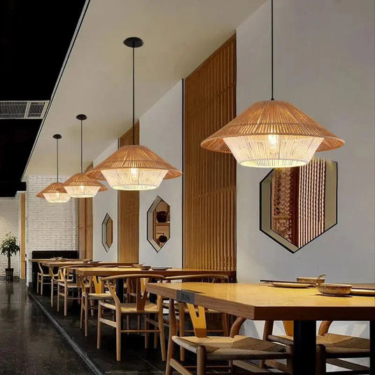 Hemp rope shade lit above a dining table in a dark paneled room