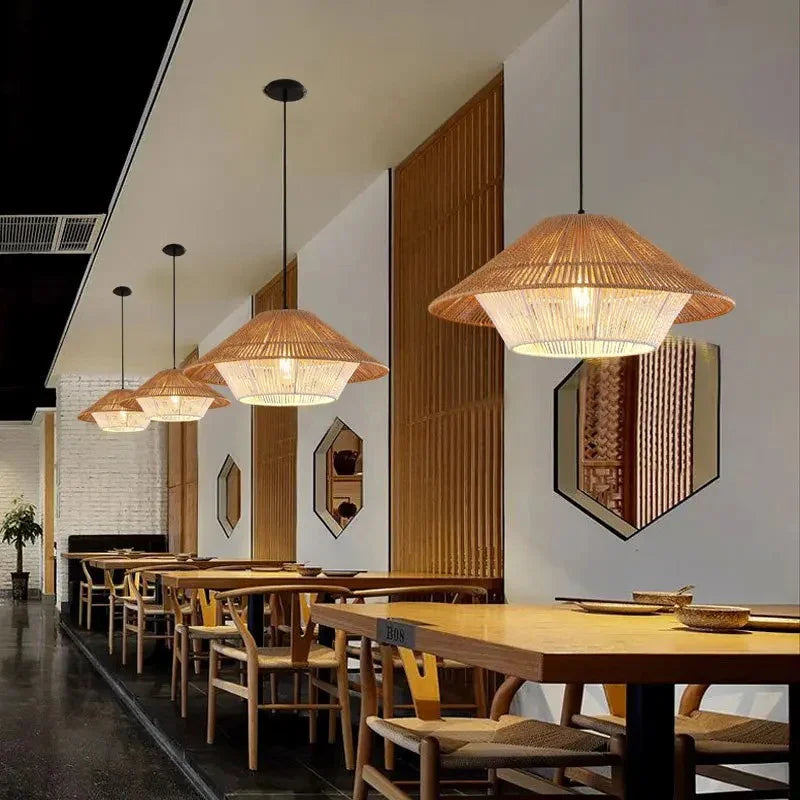 Hemp rope shade lit above a dining table in a dark paneled room