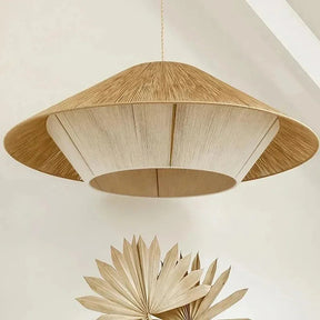 Rope pendant light with a wide flat hemp shade against a pale wall