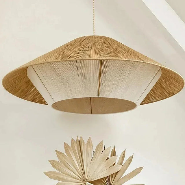 Rope pendant light with a wide flat hemp shade against a pale wall