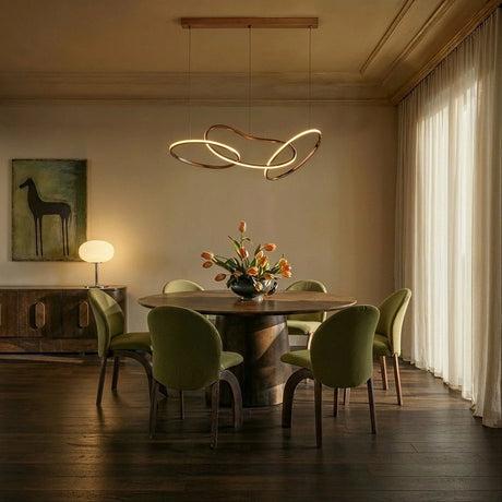 The loops lit above a round dining table with green chairs and cut flowers