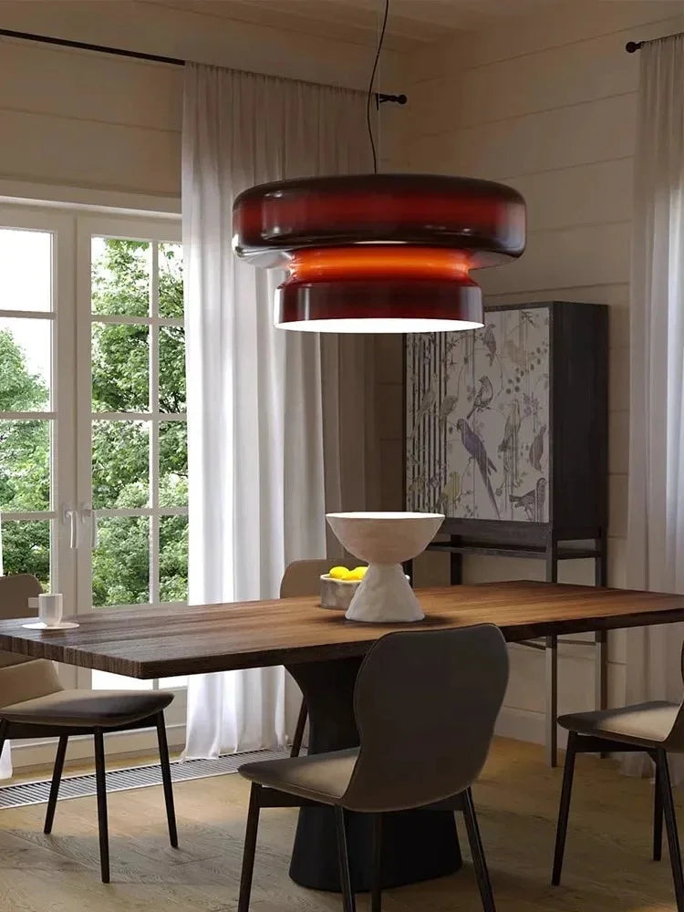 Tinted glass shade above a table with dark chairs