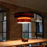 Red tinted glass shade hung against a stone wall