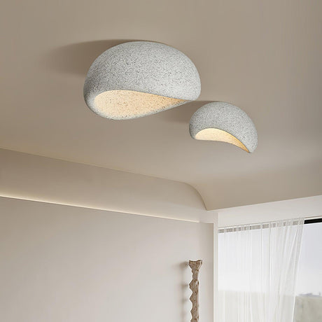 Two textured dome ceiling lights near a sheer curtain in a pale room