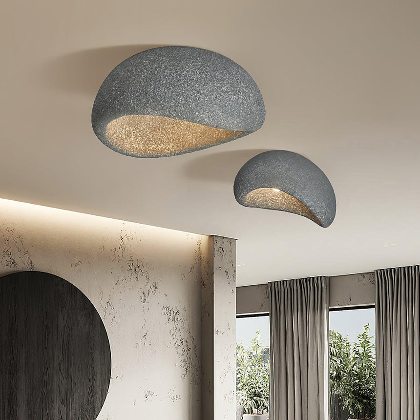 Textured dome ceiling light beside a dark circular artwork and a tall window