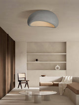 Textured dome ceiling light above a low sofa in a room with dark shelving