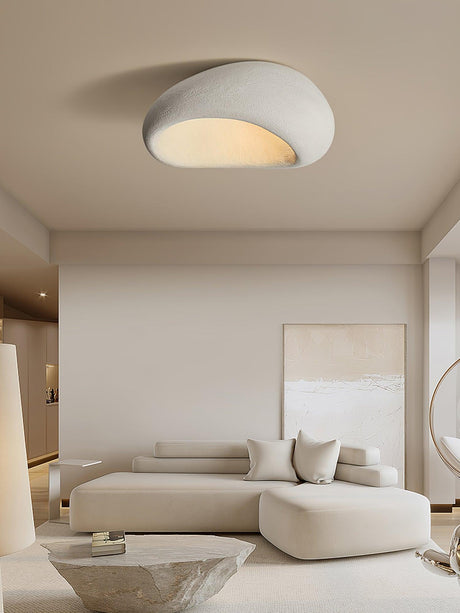 Textured dome ceiling light in a living room with a curved sofa and framed art