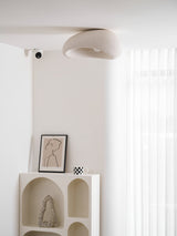Textured dome ceiling light in a white room with an arched shelf unit
