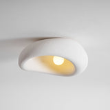 Textured dome ceiling light lit, seen from the side against a pale wall