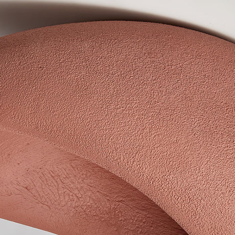 Close view of the brick red textured surface curving away from the opening