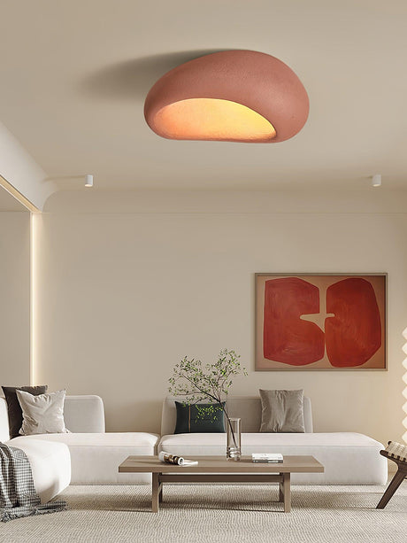 Brick red dome ceiling light in a living room with a red framed artwork