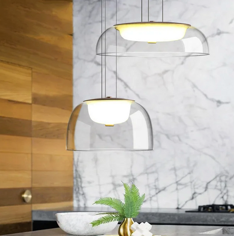 The glass dome lit above a counter with a small plant and a wood panel wall behind