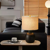 Sphere base lamp lit on a side table beside a dark gray sofa