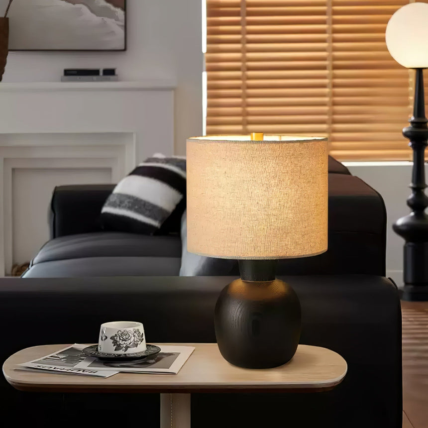 Sphere base lamp lit on a side table beside a dark gray sofa