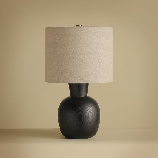 Close view of the black wood sphere base under the linen drum shade