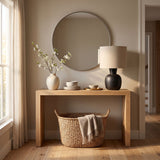 Sphere base lamp lit on a hall console below a round mirror