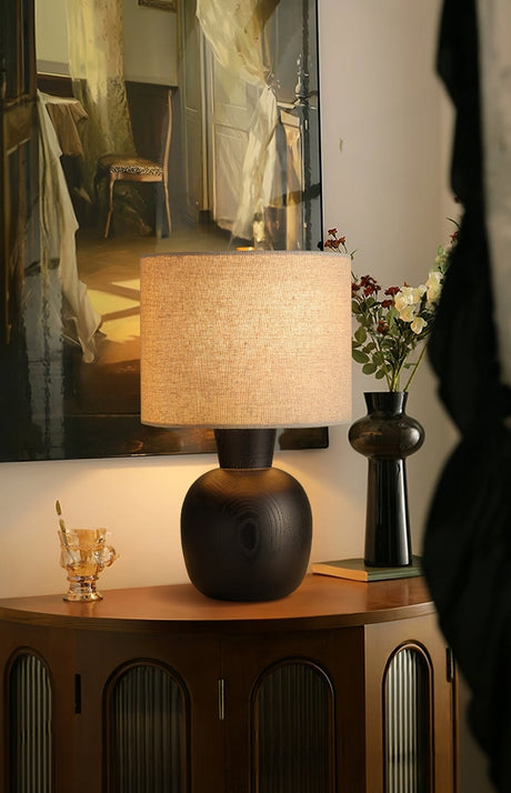 Sphere base lamp lit on a fluted cabinet beside dried flowers