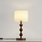Round table lamp switched on and seen from the front on a pale floor