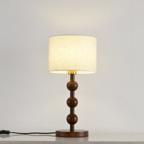 Round table lamp switched on and seen from the front on a pale floor