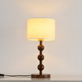 Round table lamp lit with a warm glow spreading up the wall behind