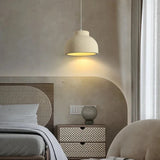 Textured dome lit beside a bed in a warm room