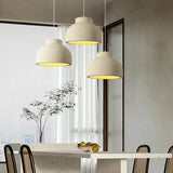Textured domes above a dining table with a branch in a vase