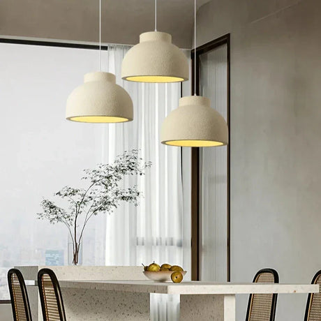 Textured domes above a dining table with a branch in a vase