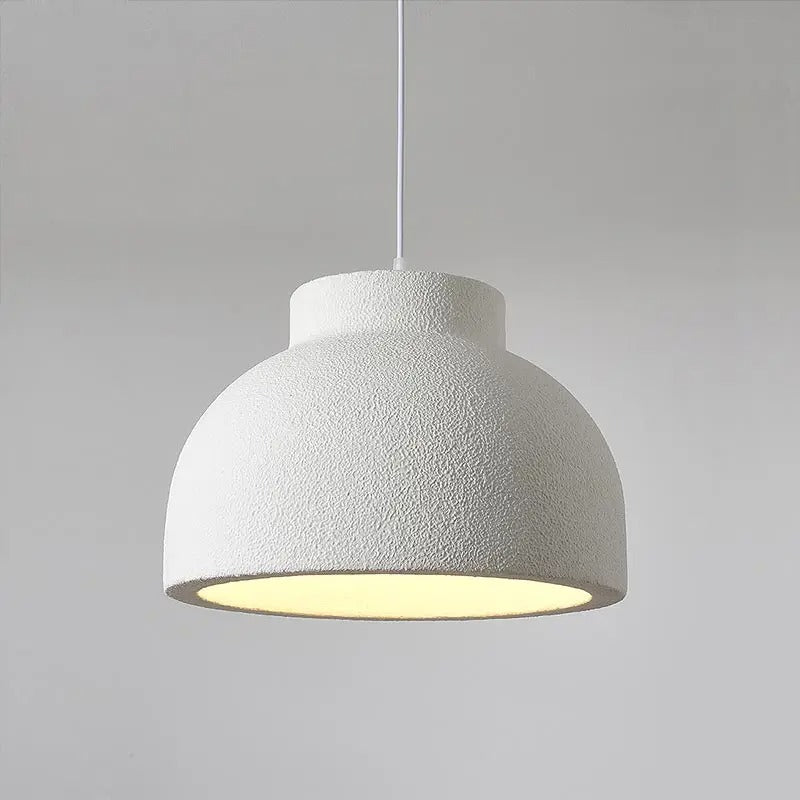 Rounded ceiling light with a textured white shade against a pale wall