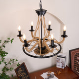 Chandelier lit next to a tall plant and a framed picture on the wall
