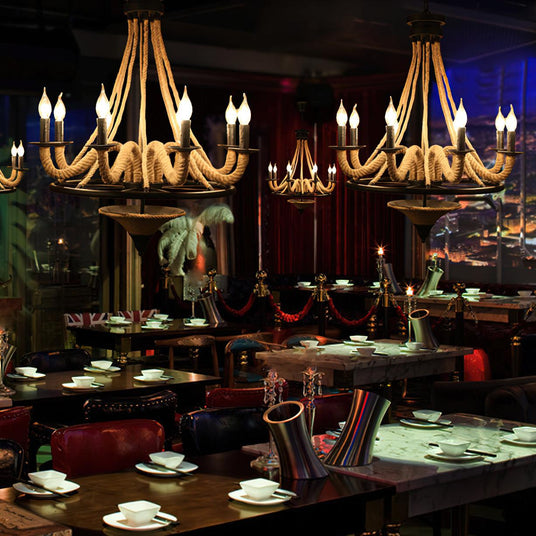 Chandelier lit over a set dining table with chairs on both sides
