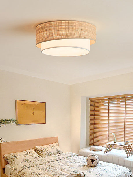 Two tier raffia ceiling light above a bed with a yellow framed print and shutters